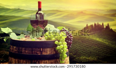 Red wine bottle and wine glass on wodden barrel. Beautiful Tuscany  background - Stock Image - Everypixel