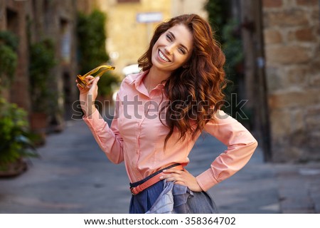 beautiful woman in summer dress walking and running joyful and cheerful smiling in Tuscany, Italy.