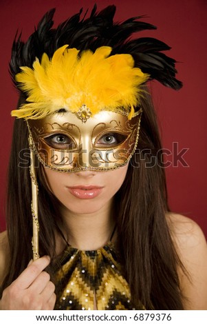 Portrait of attractive beautiful young woman wearing gold carnival mask