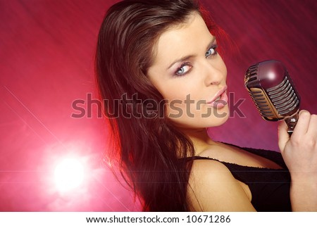 Music star.Sexy woman singing in retro mic