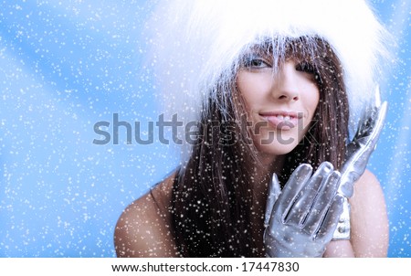 Winter Girl with beautiful make up, silver gloves  and snow flake, blue background