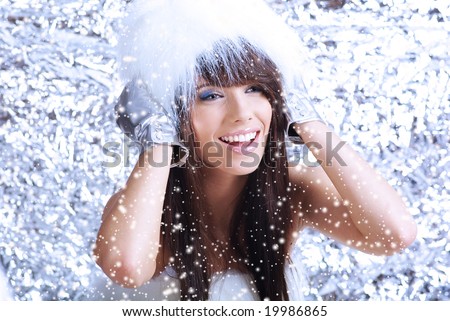Winter Girl with beautiful make up, silver gloves and snow flake, silver background
