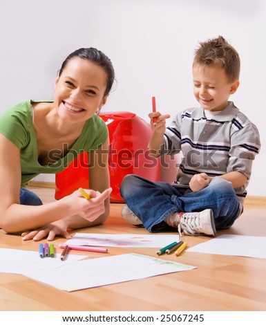 mother and a 5-year old son painting on paper