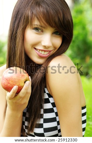 Woman holding apple. Green garden background