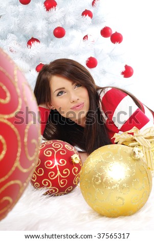 young woman with gift box next to white christmas tree