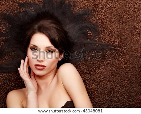 portrait of beautiful young woman with coffee beans around her