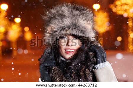 Smiling winter woman in night city