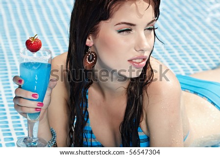 Woman with drink  in swimming pool