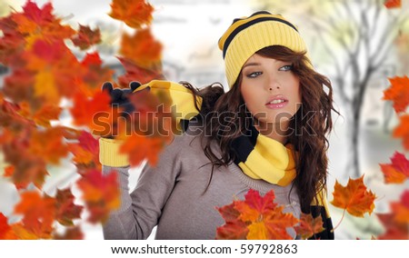 Beautiful woman wearing hat and gloves and maple leaves