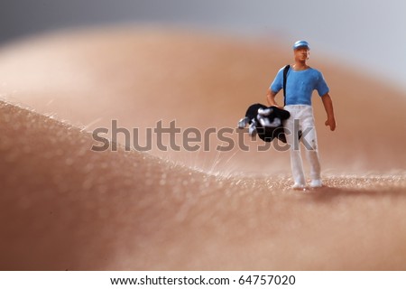Miniature Figures playing golf on naked woman body