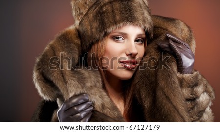 Attractive woman in brown  fur coat with hood