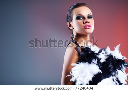Beautiful young woman in carnival mask and feather boa.