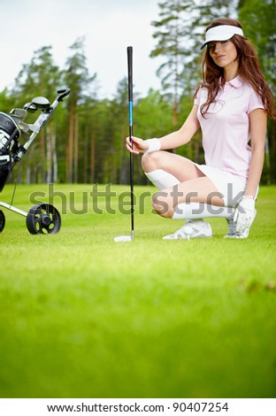 A pretty woman golfer on the putting green