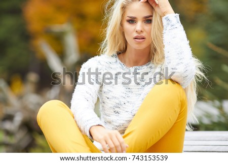 Relaxation and free time. Beauty modern girl rest on fresh air in autumn. Lovely attractive woman relax outdoor surrounded by trees and autumnal leaves.
