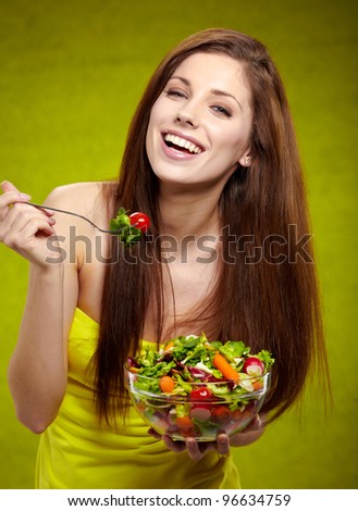 happy healthy woman with salad on green background