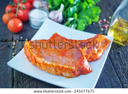 raw meat in marinad and on wooden board