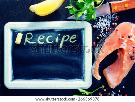 board for recipe and raw fish on a table