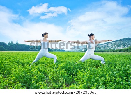 yoga women in green field