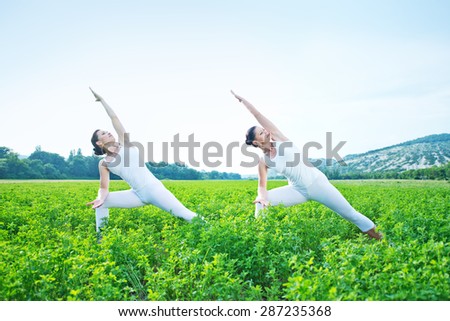 yoga women in green field