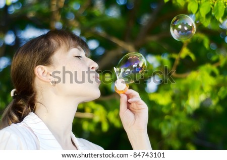 Young girl inflates soap bubbles