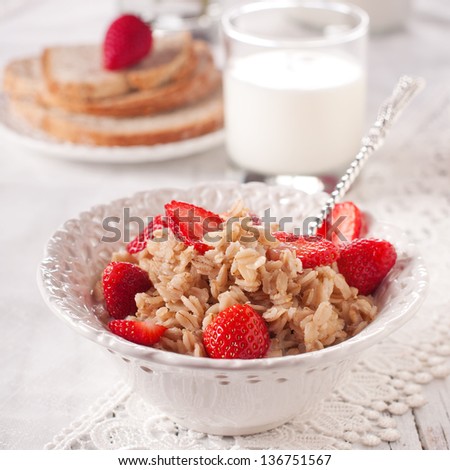 Breakfast with oatmeal, milk and strawberry, square image