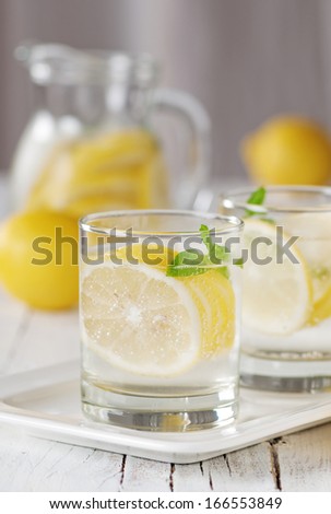 Cold lemon water with ice and mint, selective focus