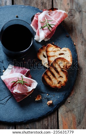 Traditional Italian crostini with ham and red wine, selective focus