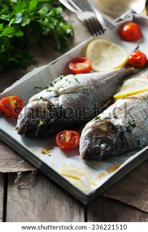 Cooked fish with parsley, tomato and lemon, selective focus