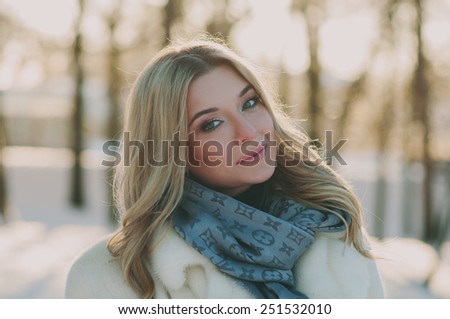 Beautiful young woman walking in the winter park, selective focus