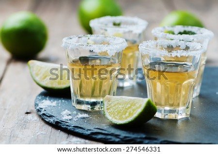 Gold tequila with lime and salt, selective focus