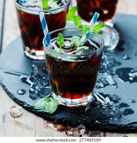 Cuba libre with ice and mint, selective focus and square image and square image