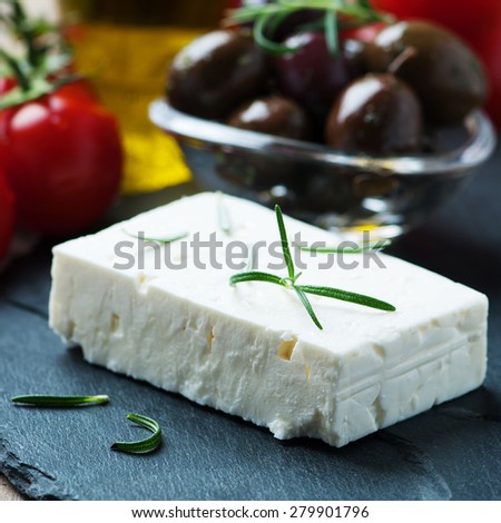 Greek cheese feta with rosemary and olives, selective focus and square image