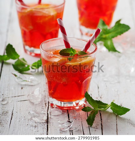 Fresh cocktail with orange, mint and ice, selective focus and square image
