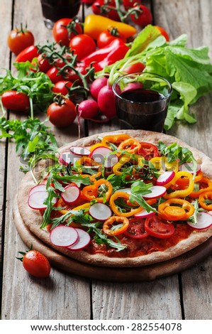 Vegan pizza with radish, tomato and paprika, selective focus