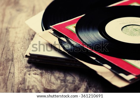 old vinyl record on the wooden table, selective focus and toned image