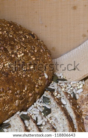 big round wholemeal bread with sunflower seeds and grain; sieve flour in background