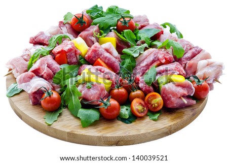 Fresh butcher cut meat assortment garnished on wooden board isolated on white background
