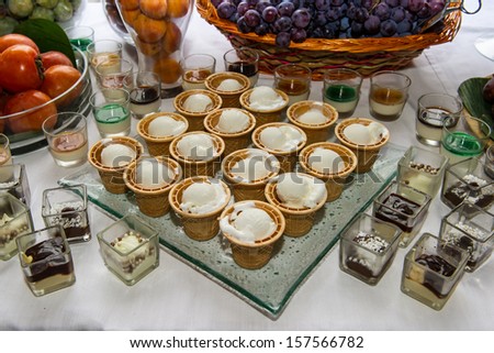 ice cream and mixed fruits with chocolates on white table for a dinner party