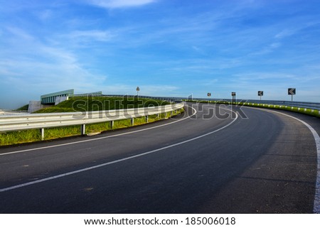 guard rail on country road over a blue sky