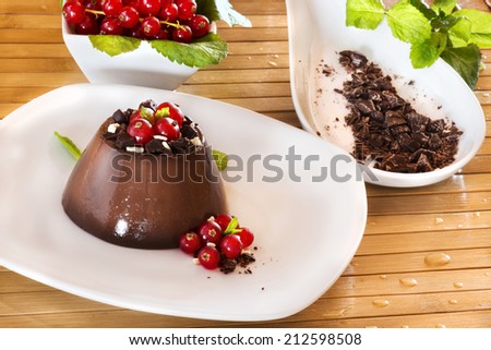Chocolate pudding with red berries on wooden table