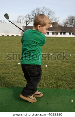 Young boy practicing his golf on the driving range