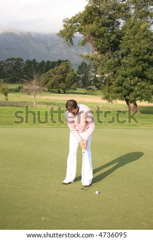 Young golfer during a putt on the golf course