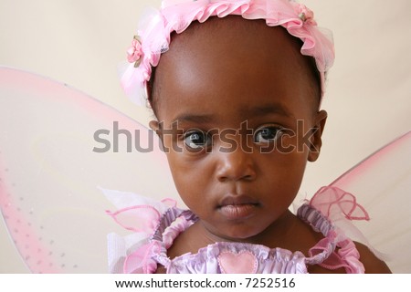 Toddler girl in a pink fairy costume with wings and head piece