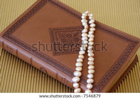 Pearls on a leather bound cover with patterns