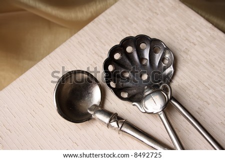 Silver spoons on a cream colored box background