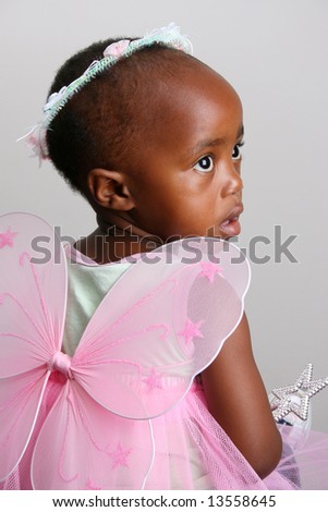 Toddler girl in a pink fairy costume with wings and head piece
