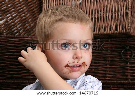 Beautiful blond boy with blue eyes and a dirty mouth, pointing at his ear