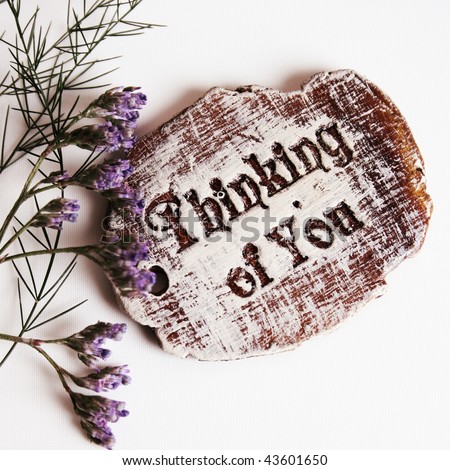 The words Thinking Of You engraved on a small wooden plaque