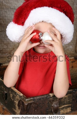 Cute christmas boy playing peek-a-boo with decorations