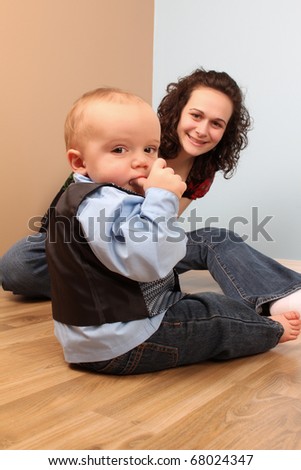 Mother and son playing indoors on a wooden floor